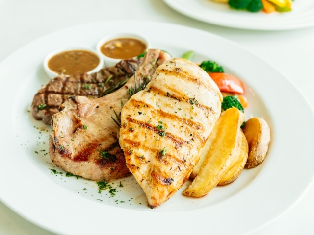 Запеченное мясо гриль на тарелке с овощами