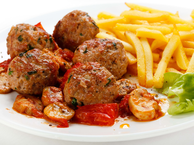 Тефтели с картофелем фри и овощами на белом фоне