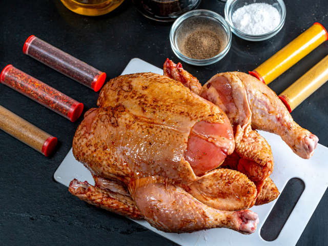 Сырая курица со специями на столе 