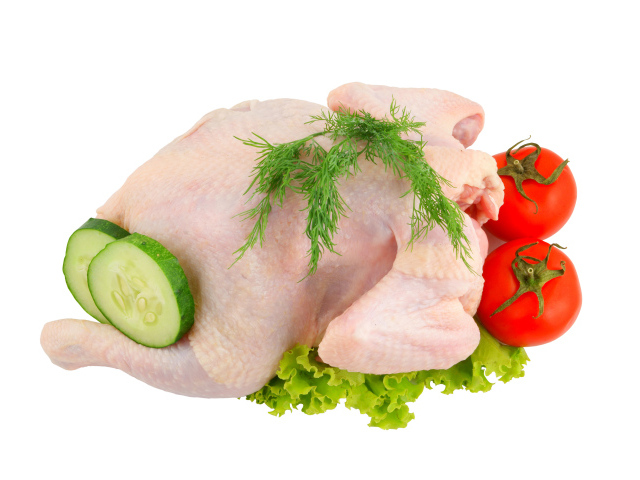 Сырая курица с помидорами, огурцами и листьями салата