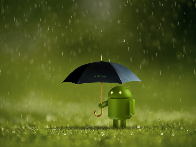 Зеленый Android стоит на траве под зонтом
