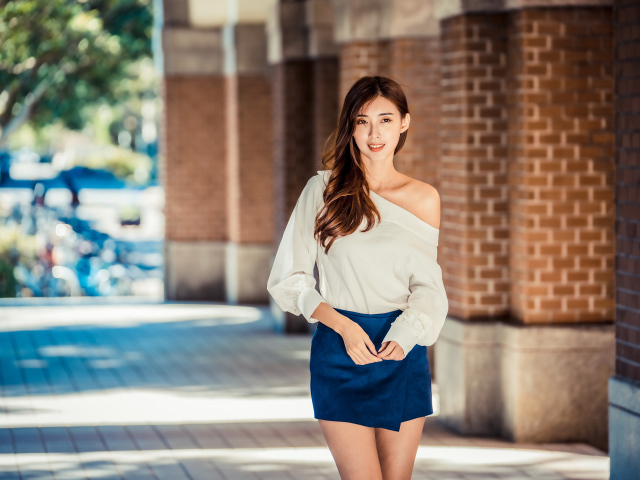 Девушка азиатка в короткой юбке у стены