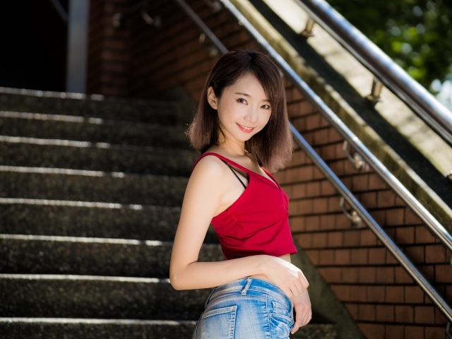 Красивая девушка азиатка стоит на ступенях 