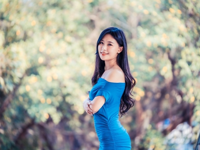 Красивая девушка азиатка с милой улыбкой в голубом платье 