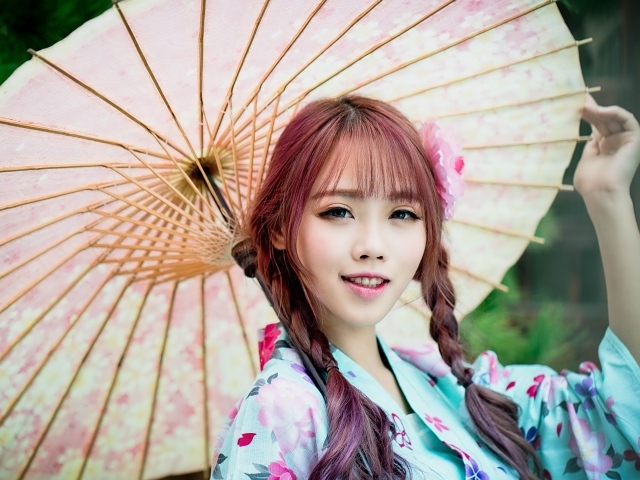 Красивая азиатка в большим зонтом 
