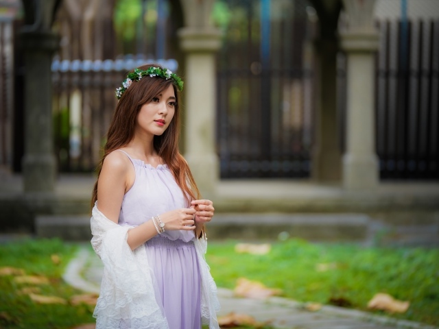 Красивая азиатка в сиреневом платье с венком на голове
