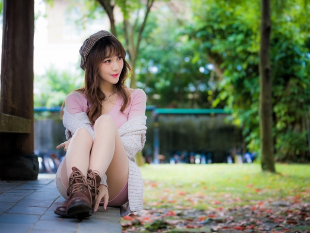 Красивая девушка азиатка сидит на земле 