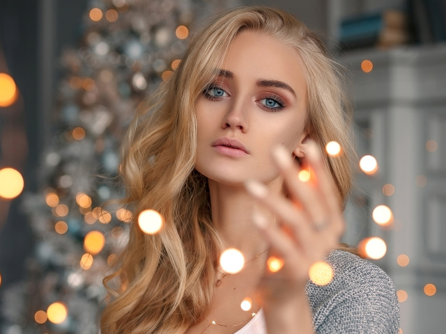 Красивая голубоглазая блондинка с гирляндой в руке