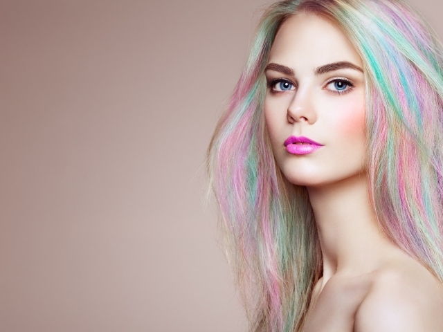Красивая голубоглазая девушка с разноцветными волосами на сером фоне
