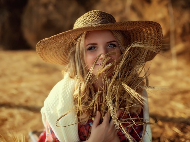 Красивая девушка в шляпе с колосьями в руке