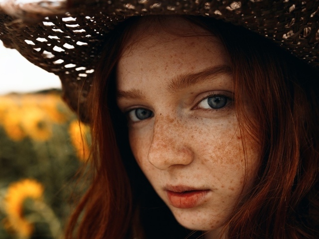 Красивая девушка в шляпе с веснушками на лице 