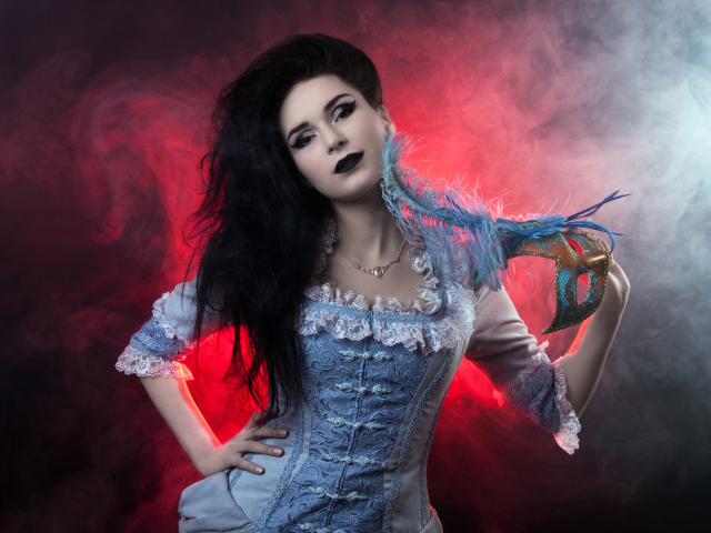 Красивая девушка в старинном платье с маской в руке