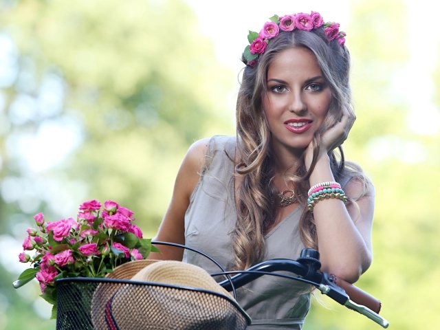 Красивая девушка с розами на велосипеде  с венком на голове