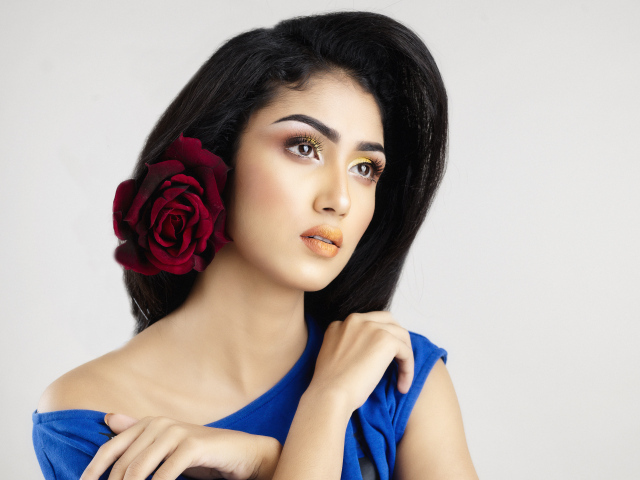 Красивая длинноволосая брюнетка с цветком розы в  волосах