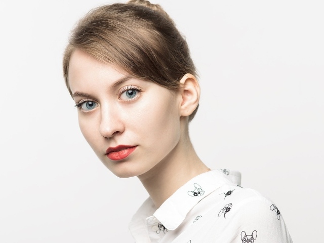 Милая голубоглазая девушка в рубашке на сером фоне