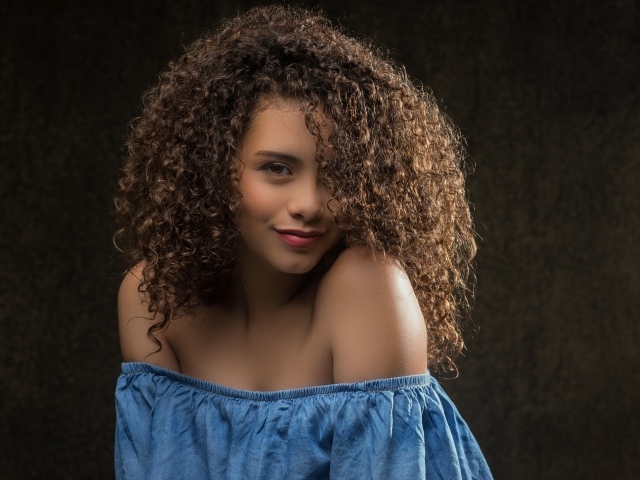 Милая кудрявая девушка в платье
