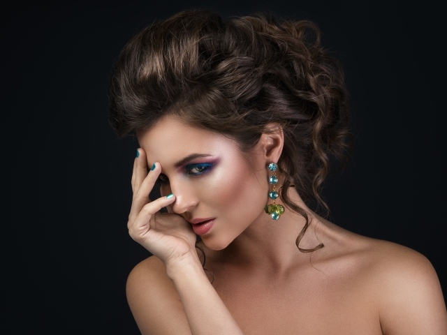 Девушка с красивой вечерней прической на сером фоне