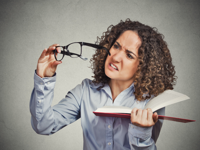 Девушка с книгой с очками в руке