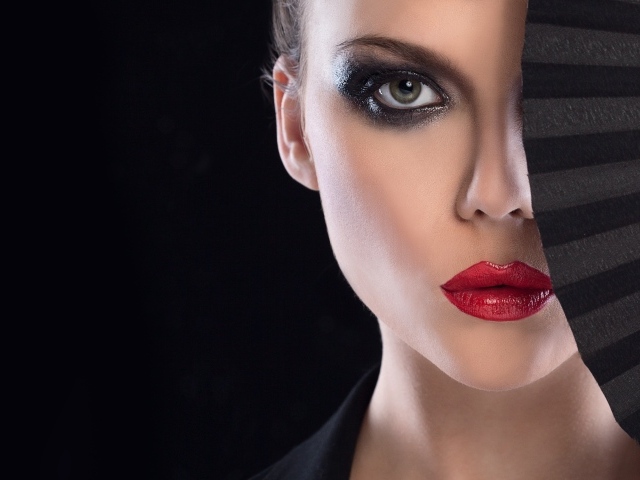 Девушка с макияжем закрывает лицо веером