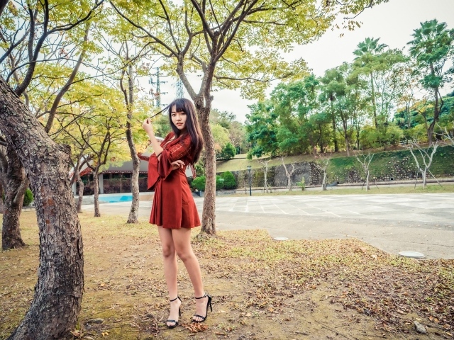 Длинноногая девушка азиатка в коротком красном платье 