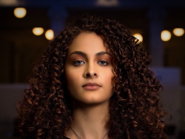 Длинные кудрявые волосы у красивой голубоглазой девушки