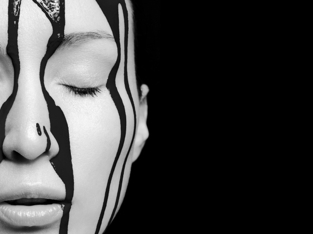 Краска стекает по лицу девушки на черном фоне