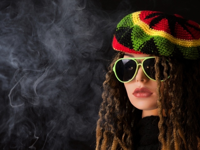 Девушка растаманка в черных очках в дыму