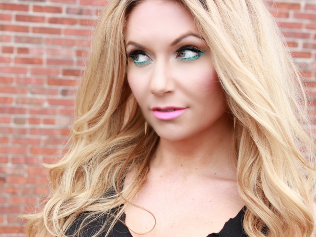 Эффектная длинноволосая блондинка у стены 