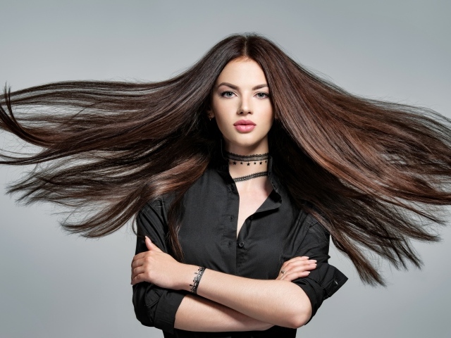 Ветер развивает волосы девушки в черной рубашке 