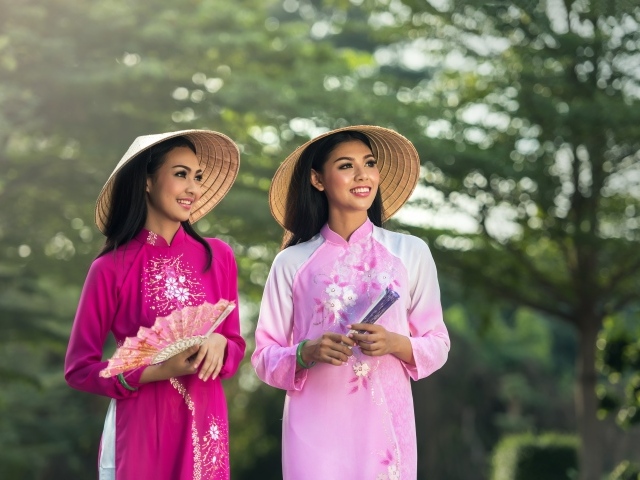 Две девушки азиатки в платьях с веером в руках