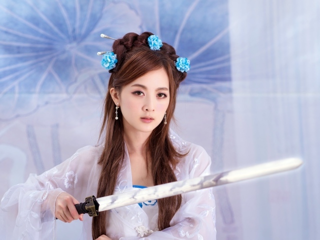 Молодая девушка азиатка с мечом в руках 