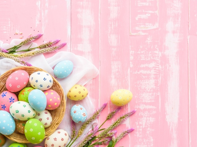 Корзина с крашеными яйцами на розовом фоне
