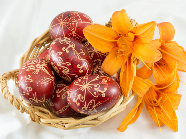 Красивые пасхальные яйца с цветами лилии в корзине