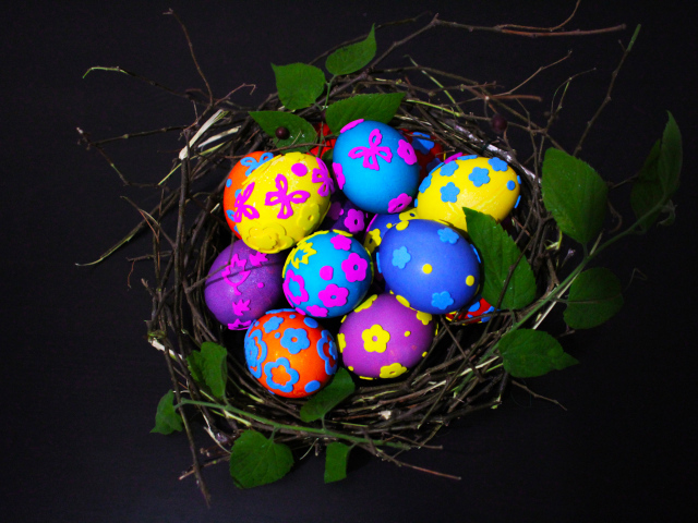 Красивые разноцветные яйца в гнезде на праздник Пасха