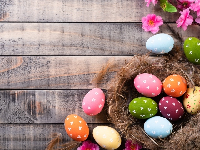 Разноцветные яйца в гнезде на столе на Великий православный праздник Пасха