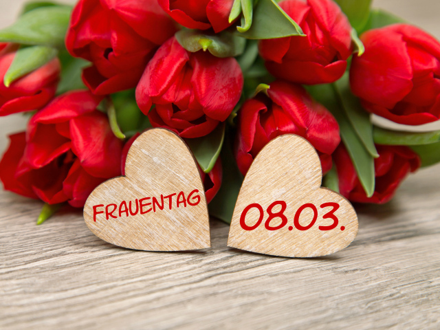Два сердечка на столе с букетом красных тюльпанов на 8 марта 