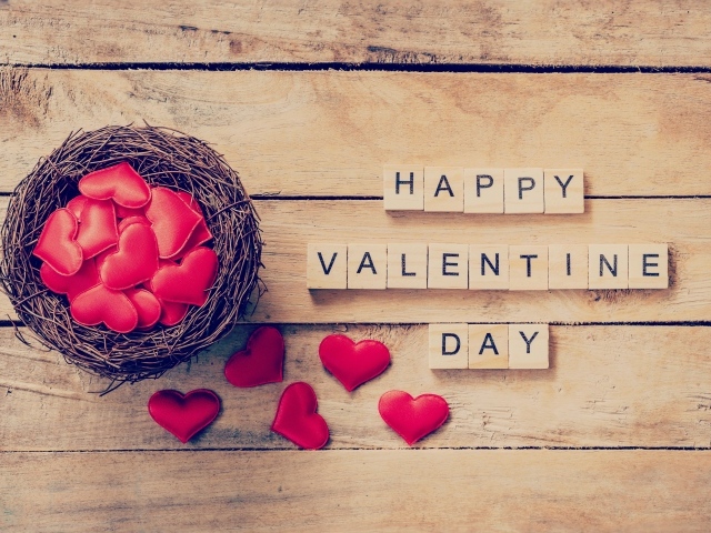 Кубики и гнездо с сердечками на деревянном столе на День Святого Валентина