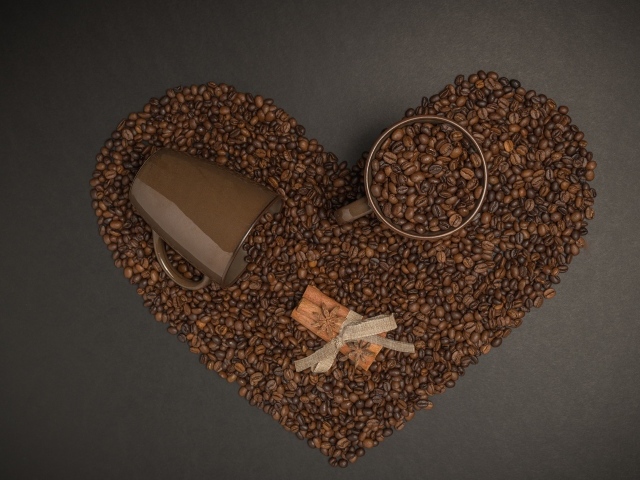 Сердце из кофейных зерен на сером фоне с кружками 