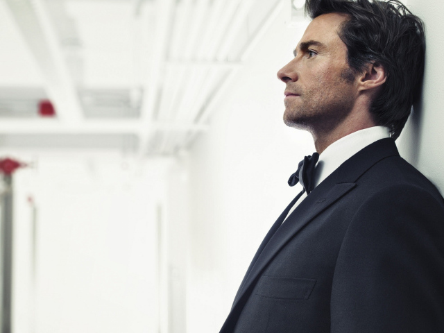 Мужчина в костюме, актер Хью Джекман у стены