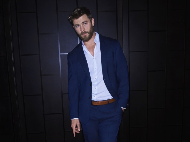 Австралийский актер Крис Хемсворт в костюме у стены