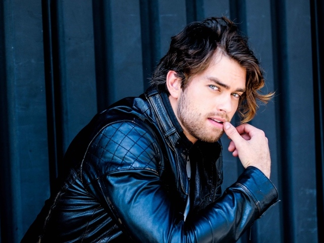 Красивый мужчина, актер Пирсон Фоде в черной кожаной куртке