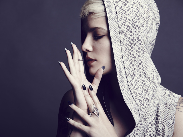 Певица Холзи в капюшоне на сером фоне