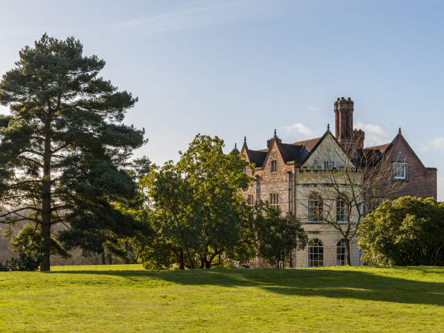 Красивый дом с деревьями и зеленым газоном