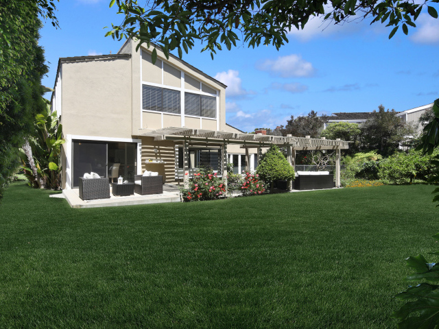 Двухэтажный дом с зеленым газоном 