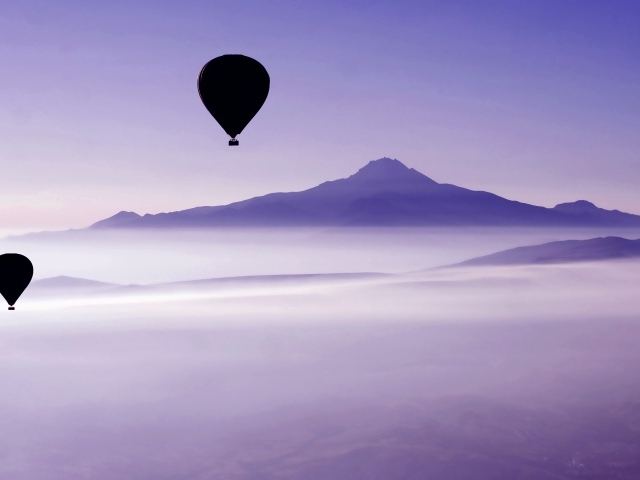 Два воздушных шара в небе над облаками