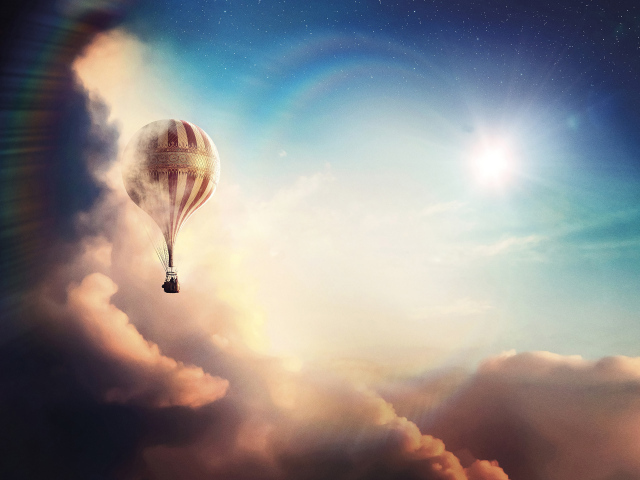 Большой воздушный шар летит над облаками на фоне солнца
