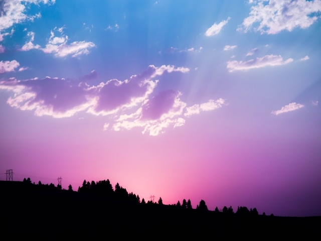 Красивое сиреневое небо с яркими лучами солнца