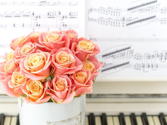Красивый букет розовых роз стоит на пианино 