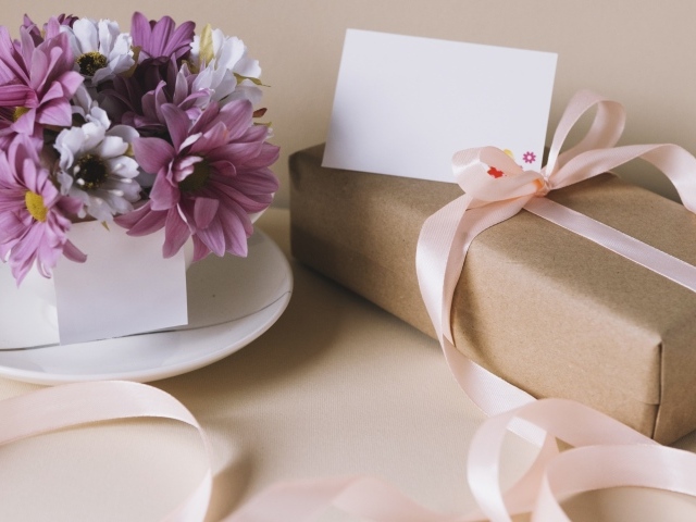 Букет хризантем на столе с подарком для любимой 