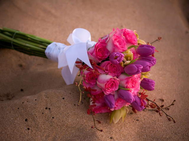 Красивый букет роз с тюльпанами лежит на песке